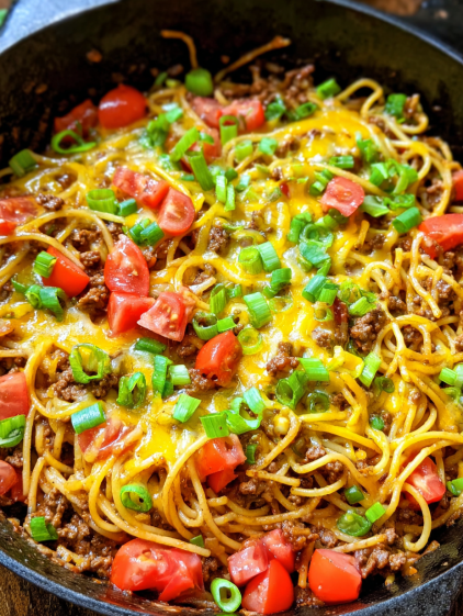 A close up of a bowl of spaghetti with meat sauce and tomatoes.