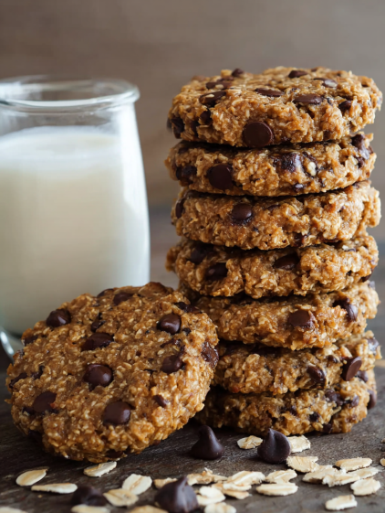A stack of chocolate chip cookies with a glass of milk.