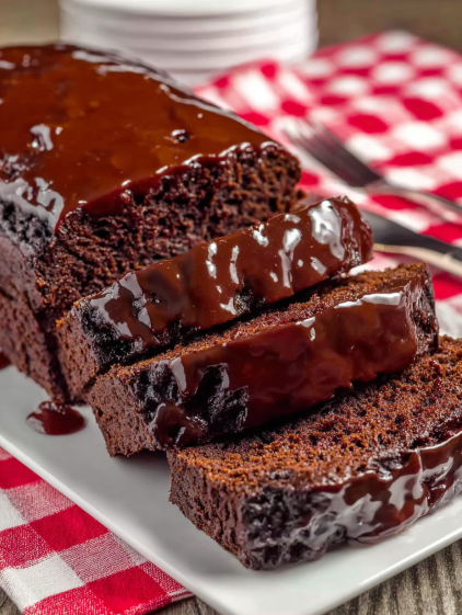 A slice of chocolate cake with chocolate sauce drizzled on top.