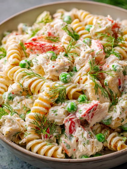 A bowl of pasta with chicken and peas.