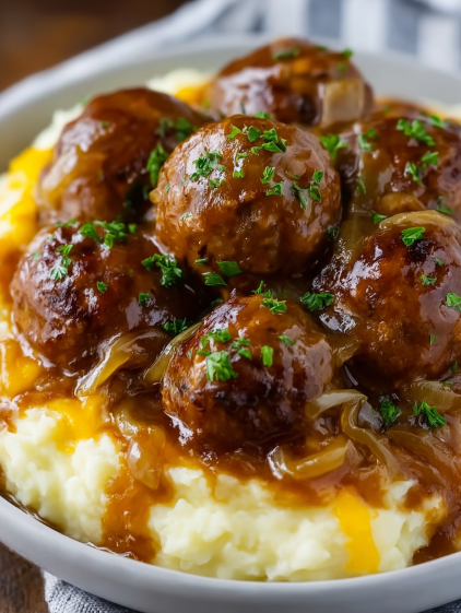 A bowl of food with meatballs and mashed potatoes.