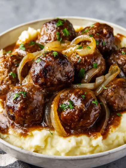 A bowl of meatballs and potatoes.