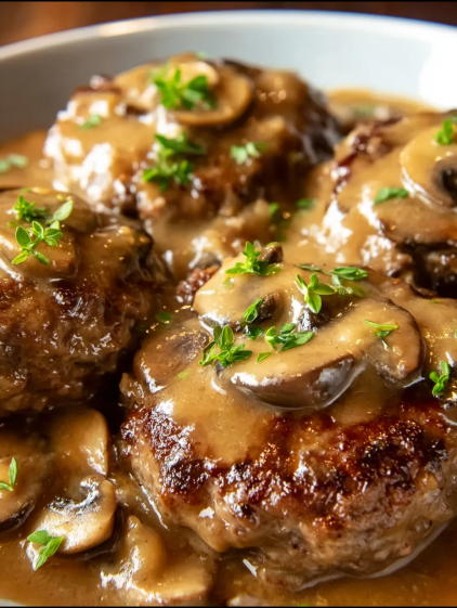 Meat covered in gravy and mushrooms.