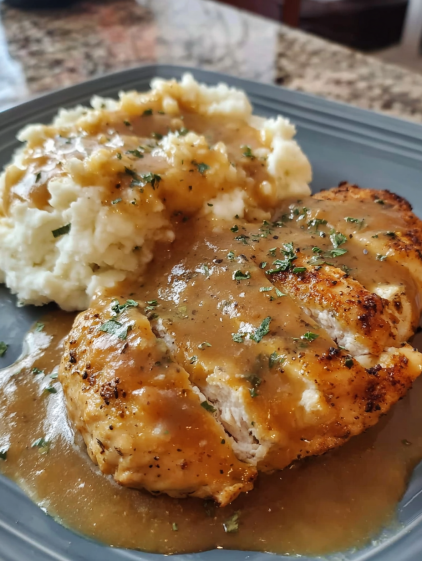 A plate of food with a chicken breast and mashed potatoes.