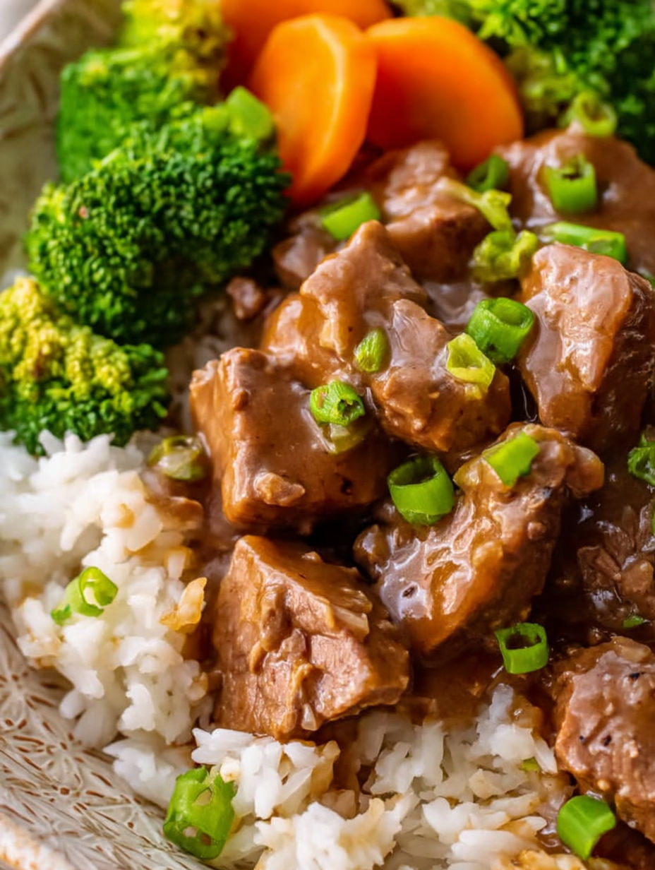 A close up of a plate of beef tips and gravy.