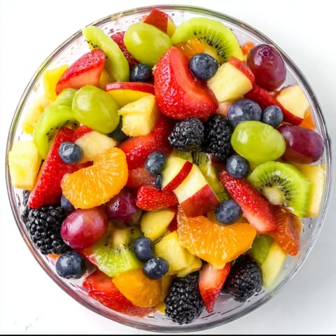 A bowl of fruit salad with kiwi, strawberries, blueberries, and oranges.