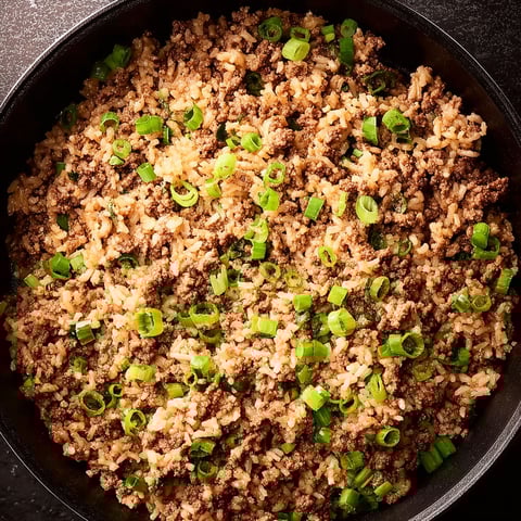 A bowl of rice with green onions.
