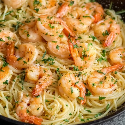 A dish of shrimp scampi with a side of pasta.