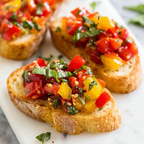 A slice of bread with tomatoes and basil on it.