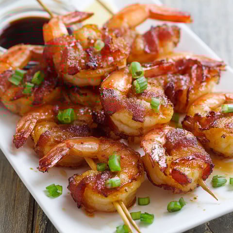 Bacon wrapped shrimp on a plate.