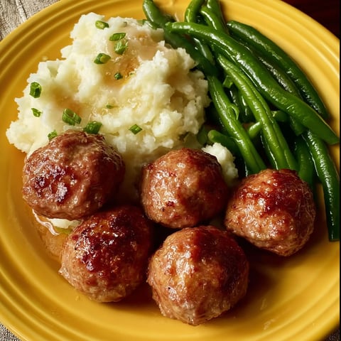 A plate of meatballs and potatoes.