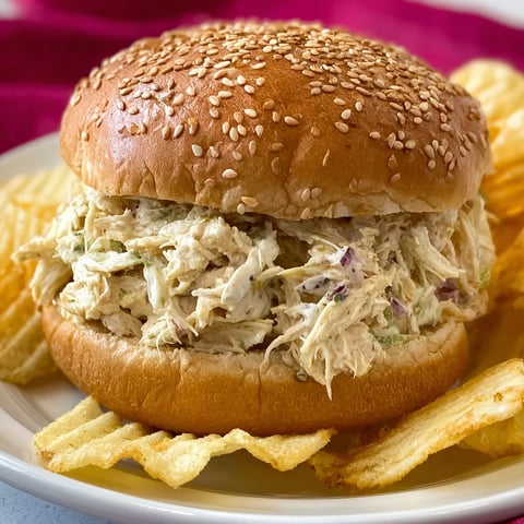 A sandwich with shredded chicken on a bun.
