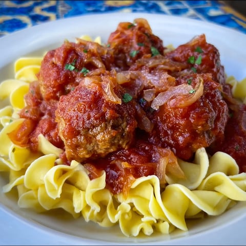 A plate of meatballs in a red sauce.