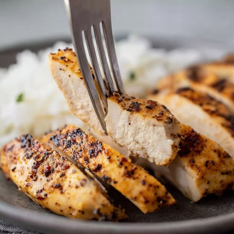 A fork is being used to eat chicken.