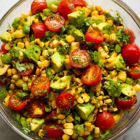 A bowl of roasted corn salad with avocado.