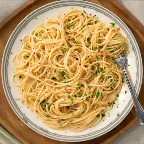 A plate of spaghetti with garlic and oil.